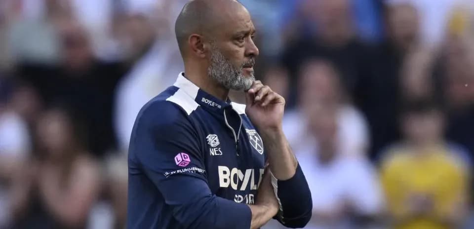 Coach observing the match with a thoughtful expression