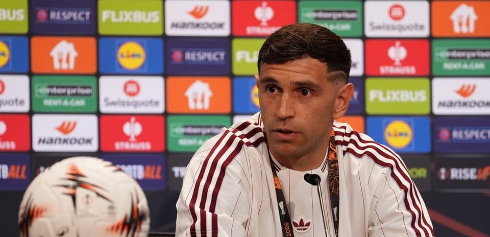 Player speaking at press conference with a football