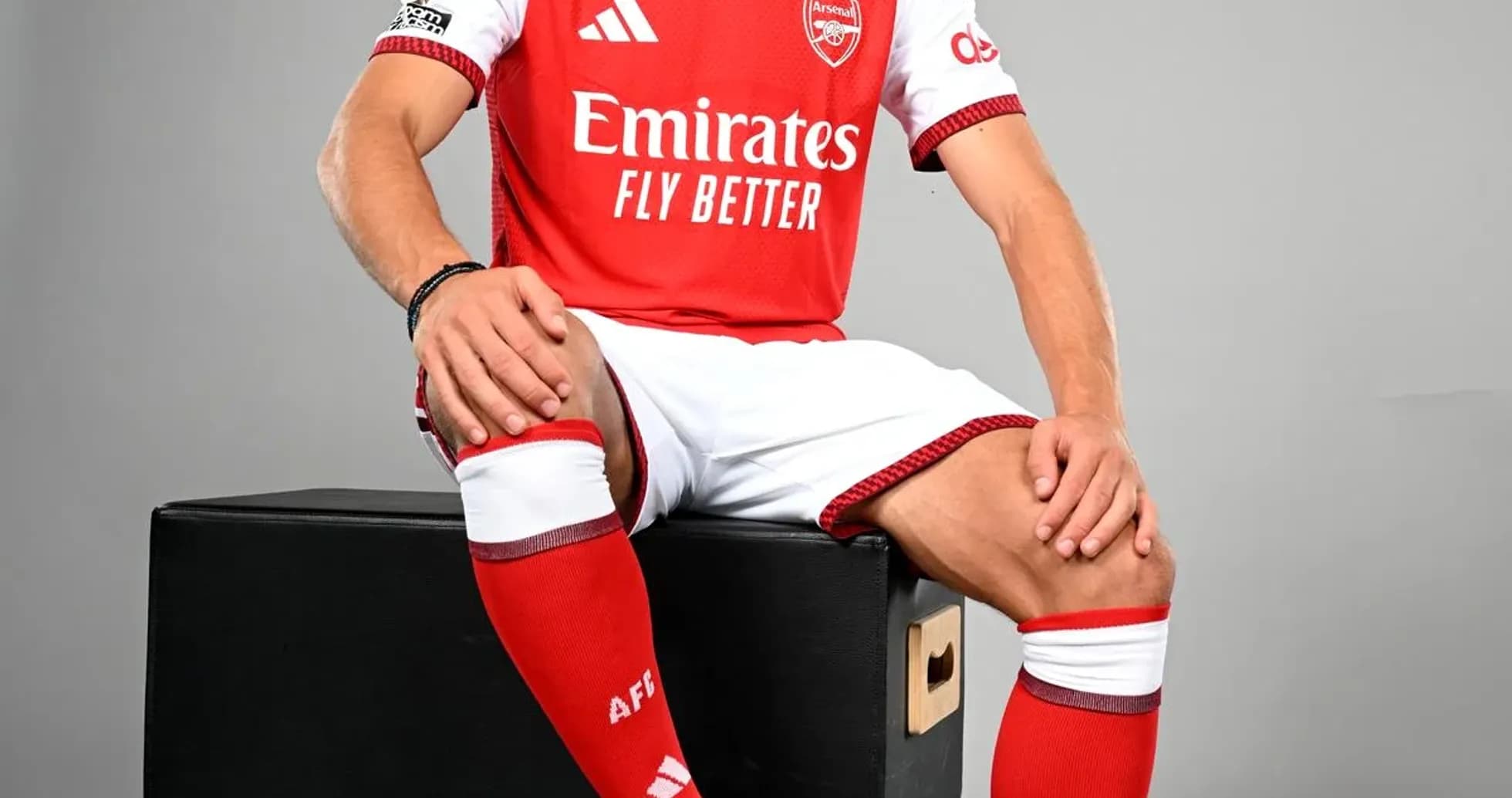 Player in Arsenal kit posing with soccer ball