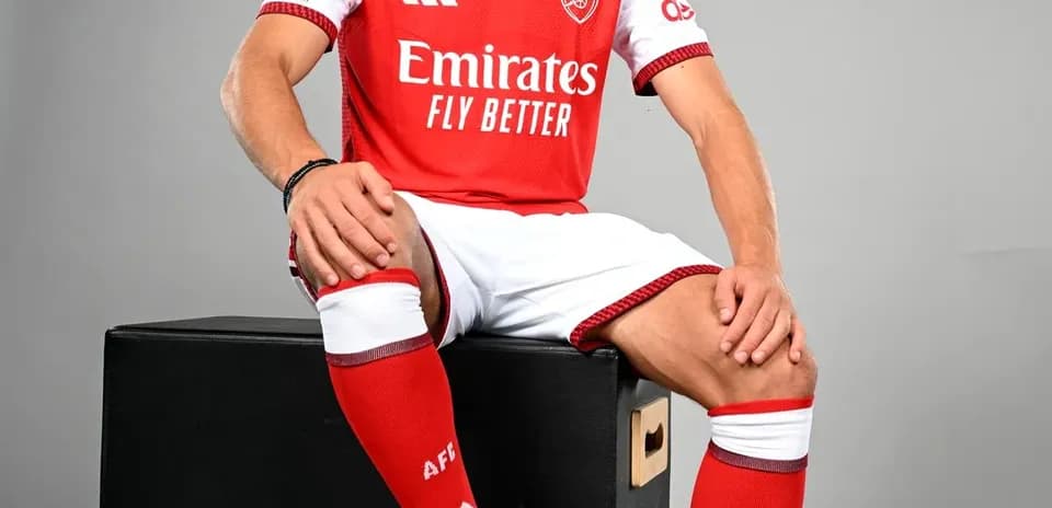 Player in Arsenal kit posing with soccer ball