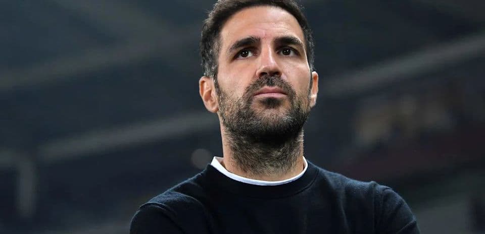 Man in black sweater observing from sidelines