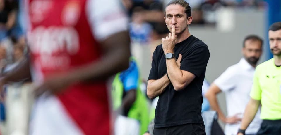 Coach observing the match with finger on lips