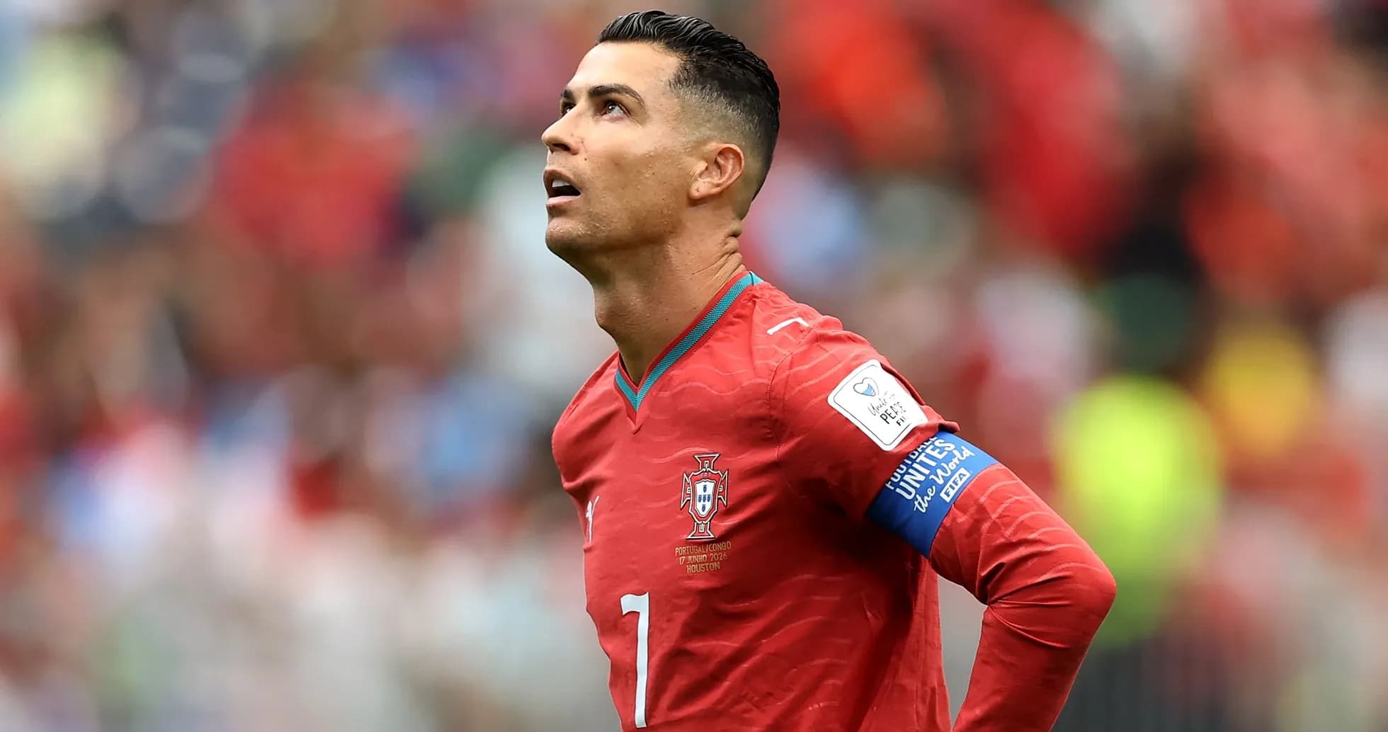 Player in red jersey looking upwards on field