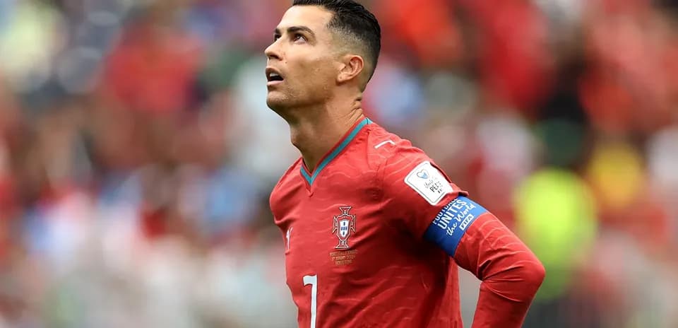 Player in red jersey looking upwards on field