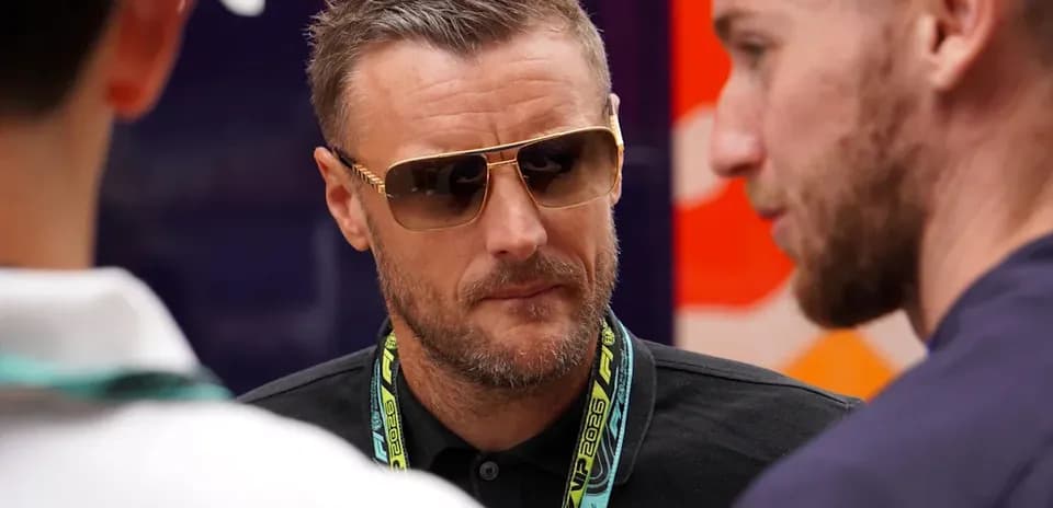 Man in sunglasses speaking with two others