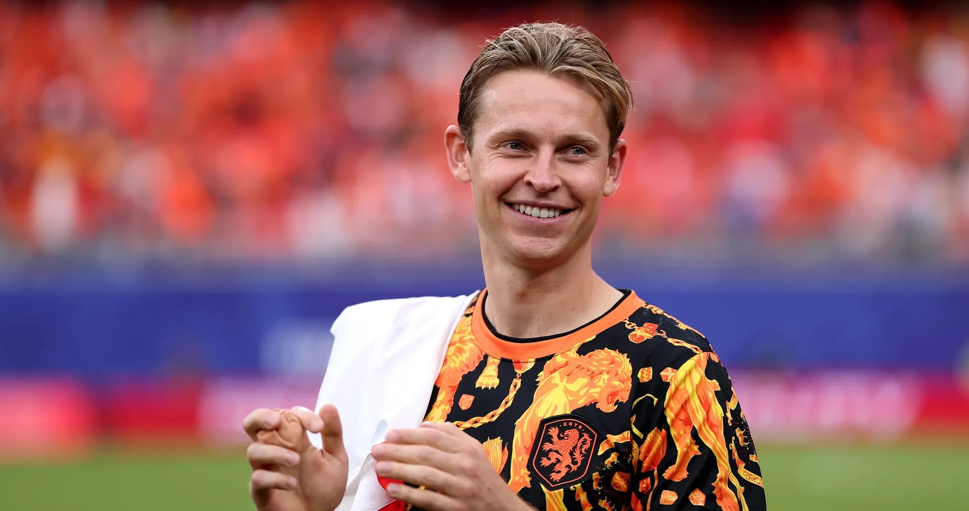 Player in vibrant shirt smiling at the stadium