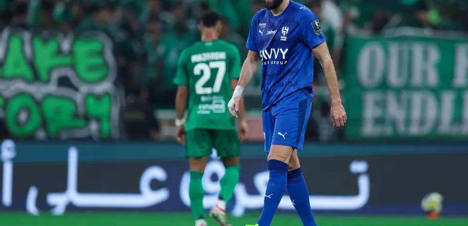 Player in blue jersey walking on pitch during match