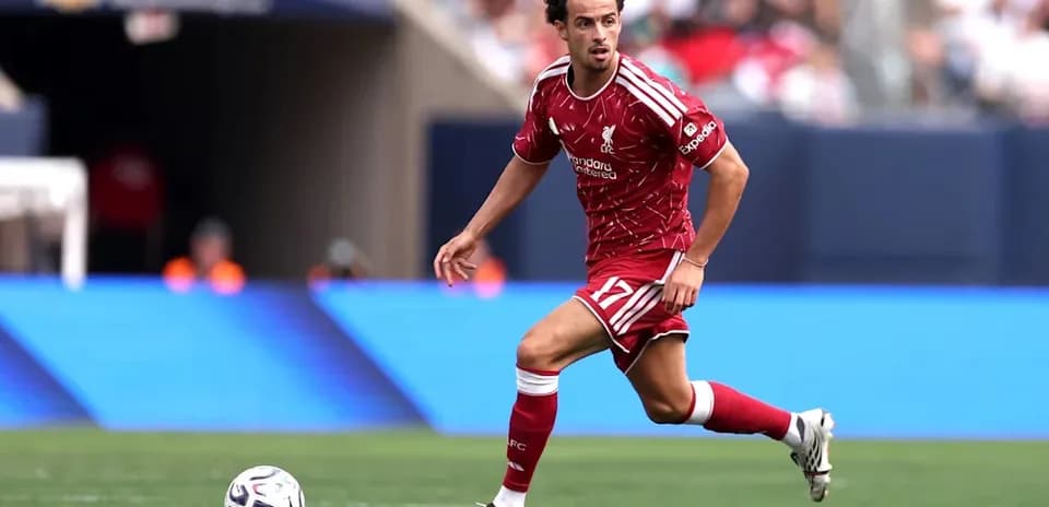 Player in red Liverpool kit running with ball