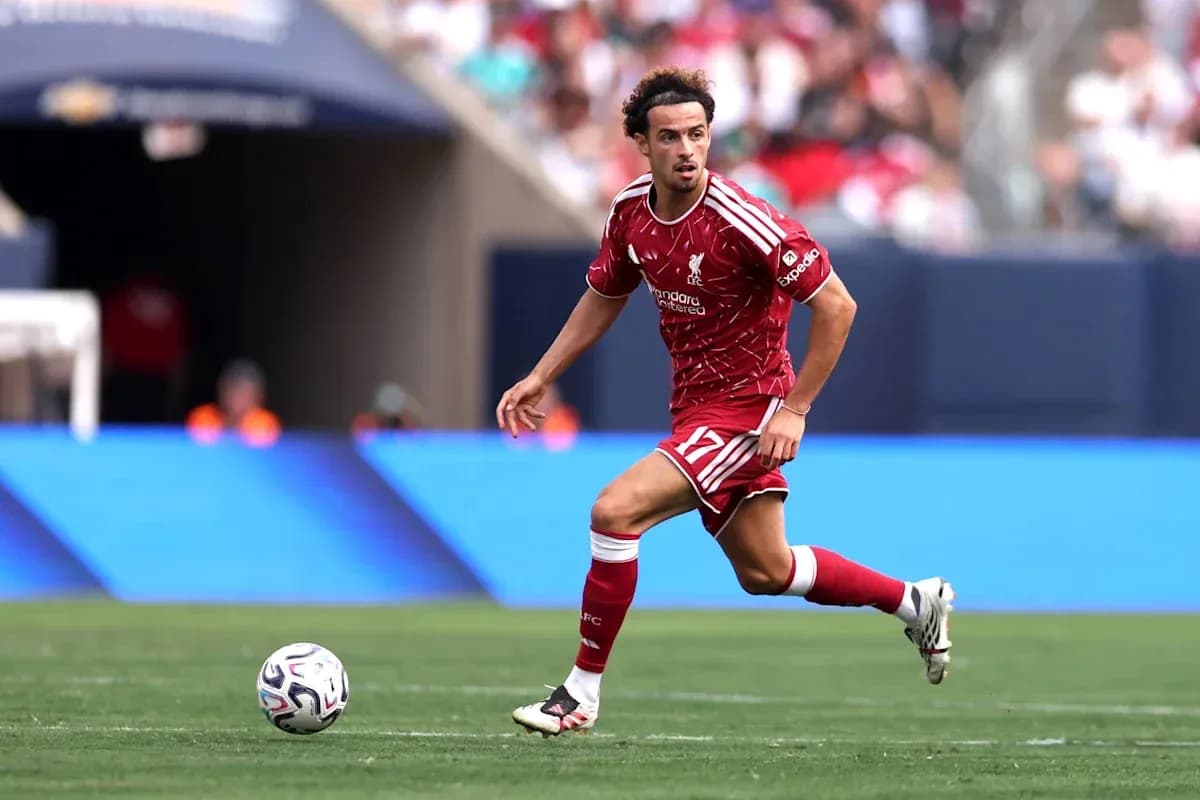 Player in red Liverpool kit running with ball