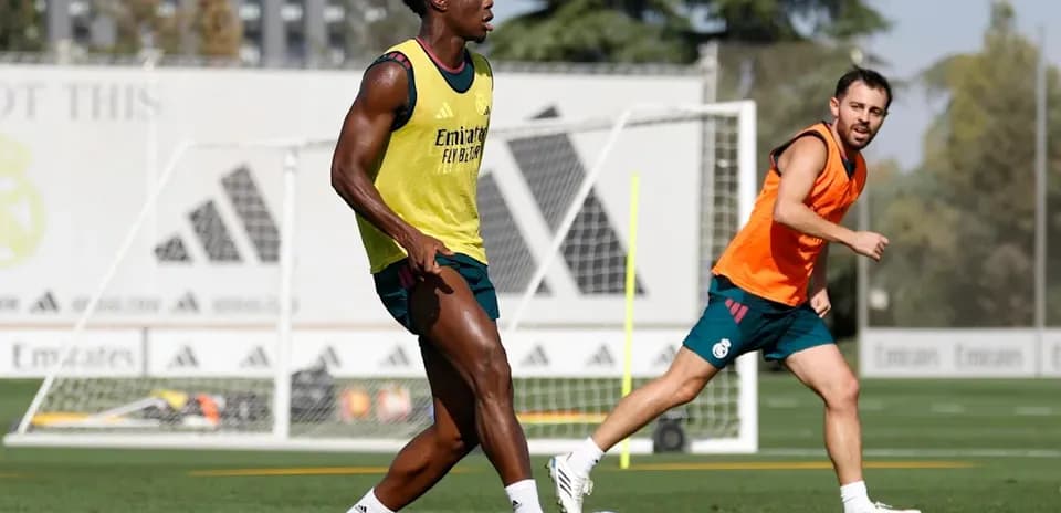 Two players training on the pitch with soccer ball