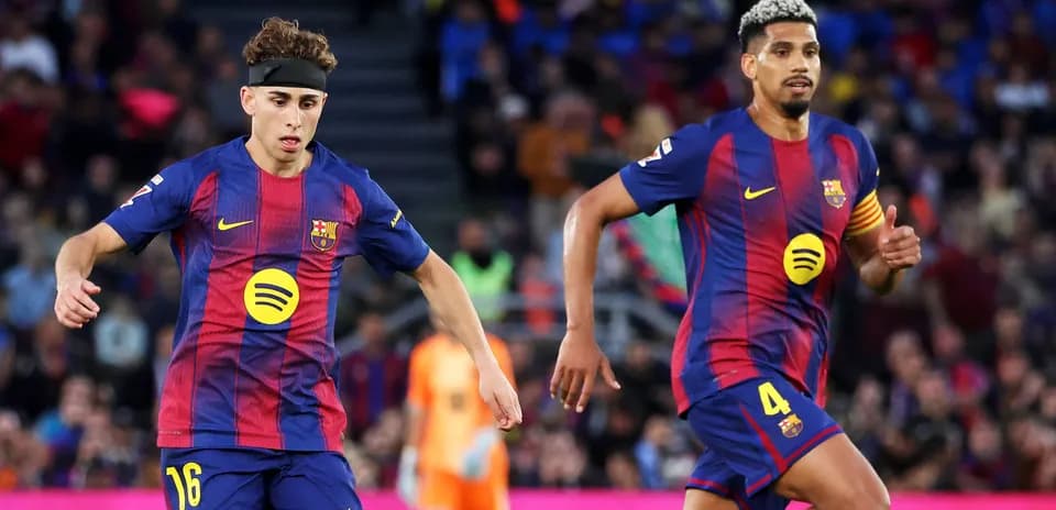 Two FC Barcelona players running on the field