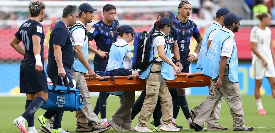 Medical team carrying player on stretcher during match