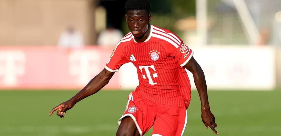 Player in red Bayern Munich kit running on pitch