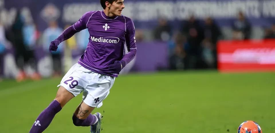 Player in purple jersey chasing the ball on field
