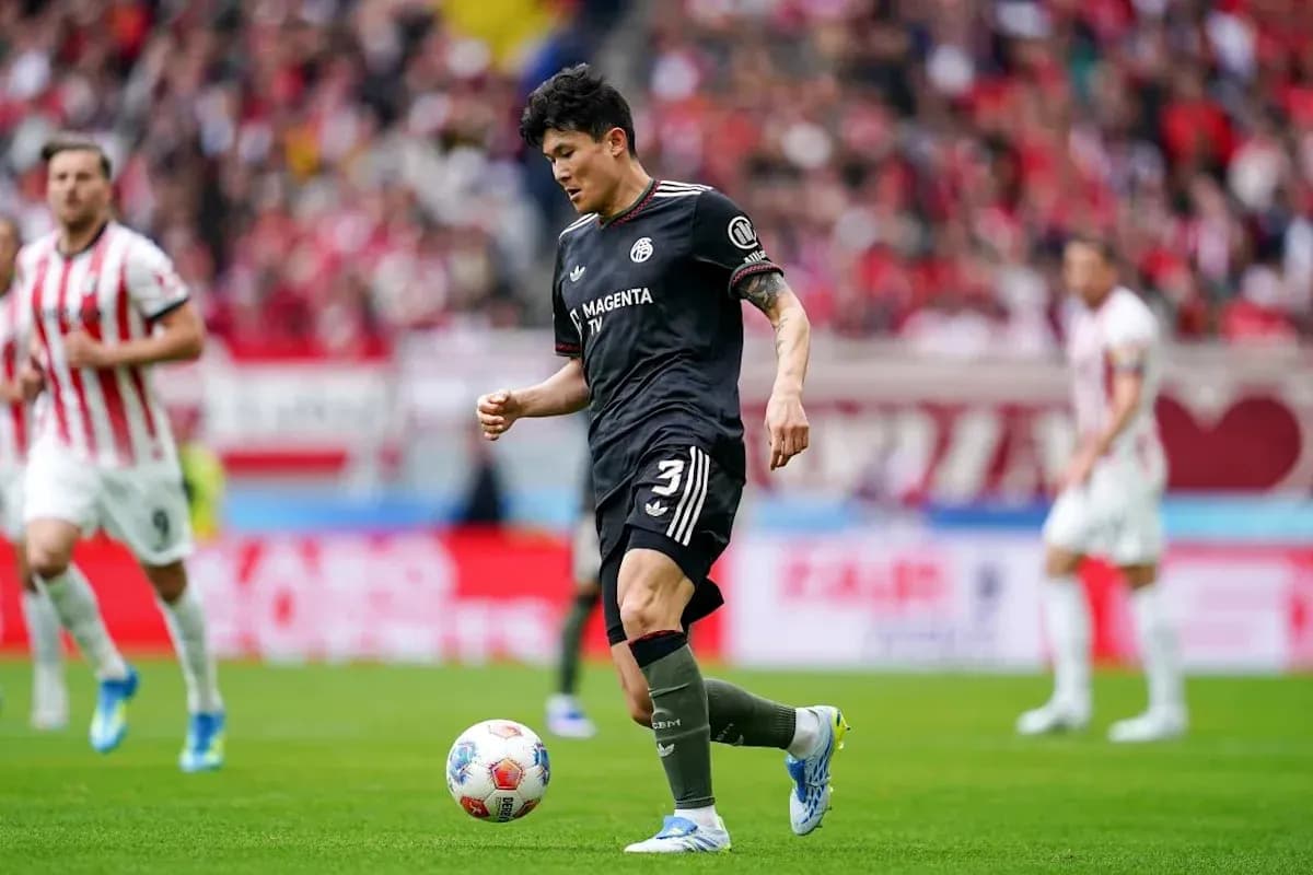 Player in black kit preparing to kick soccer ball
