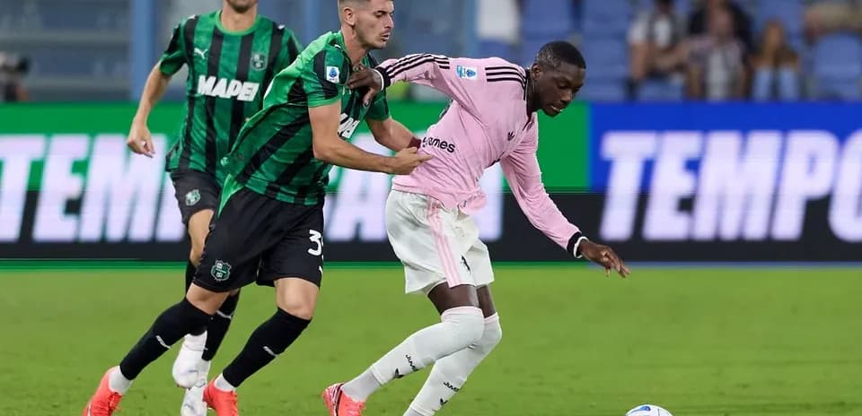 Sassuolo player tackling Juventus player during match