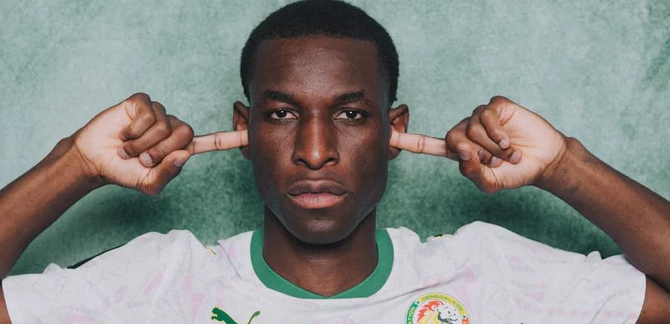 Player in Senegal jersey covering ears with fingers