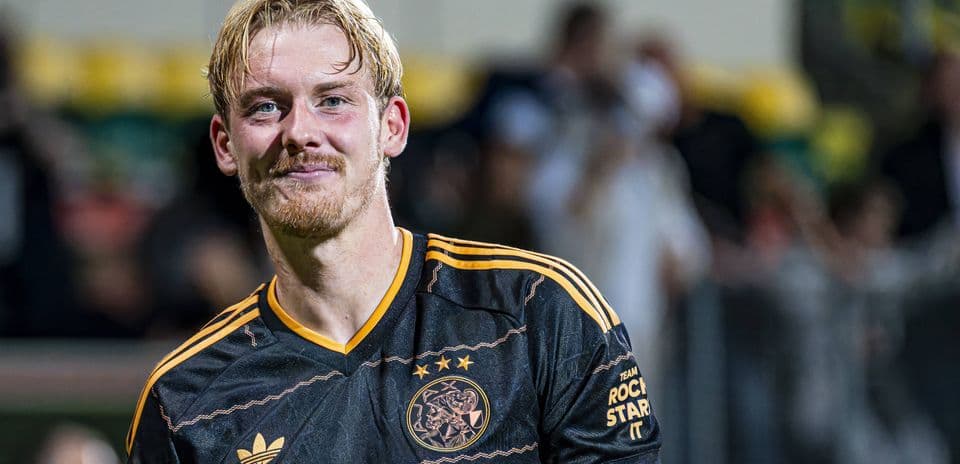 Player smiling in Ajax football jersey after match