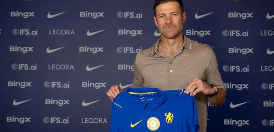 New manager holding Chelsea jersey at announcement event