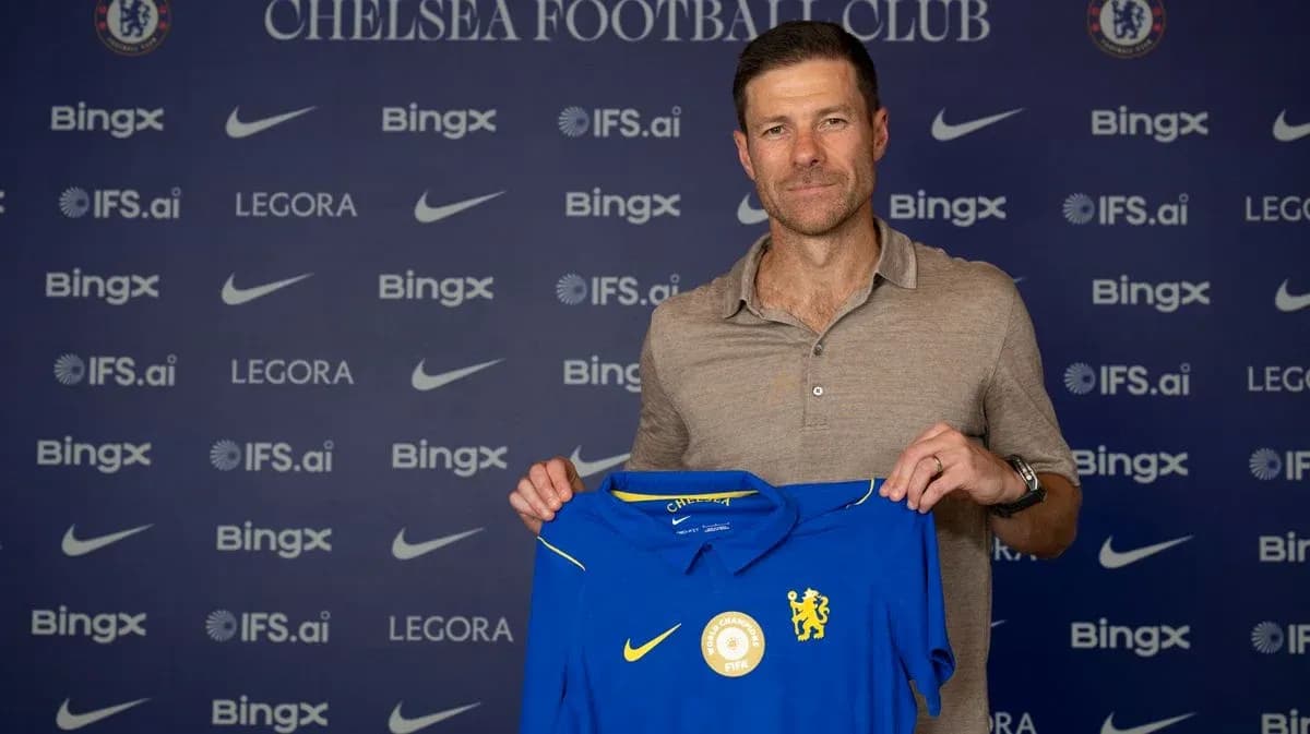 New manager holding Chelsea jersey at announcement event