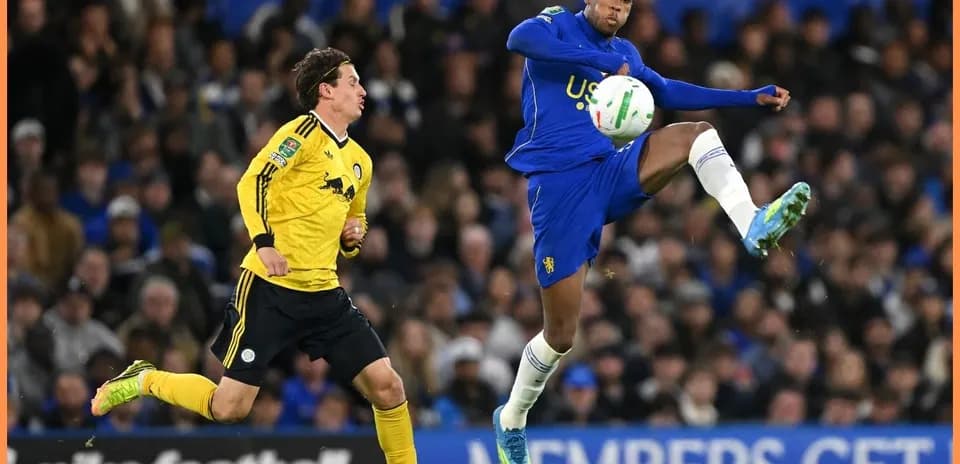 Player in blue kicking ball during match action