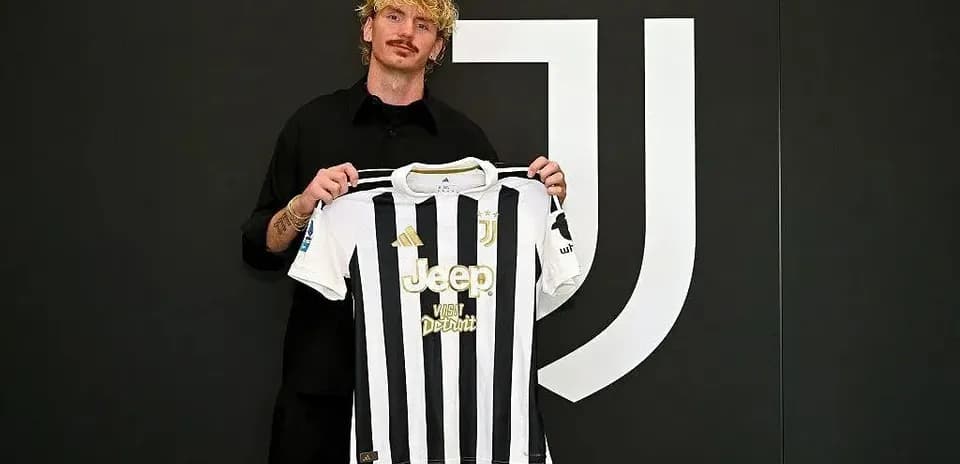 Player holding Juventus jersey during announcement event