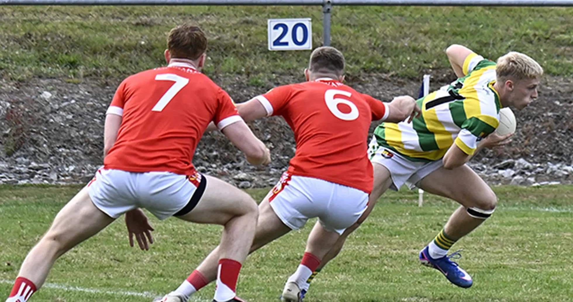 Player in green jersey evading two red defenders