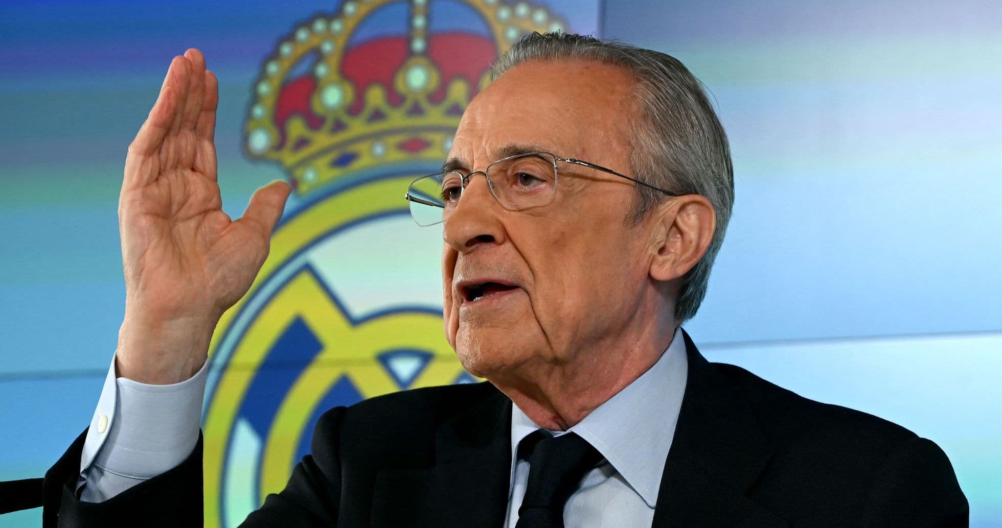 Official speaking during press conference with Real Madrid logo