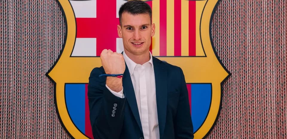 Player posing with Barcelona club logo in background