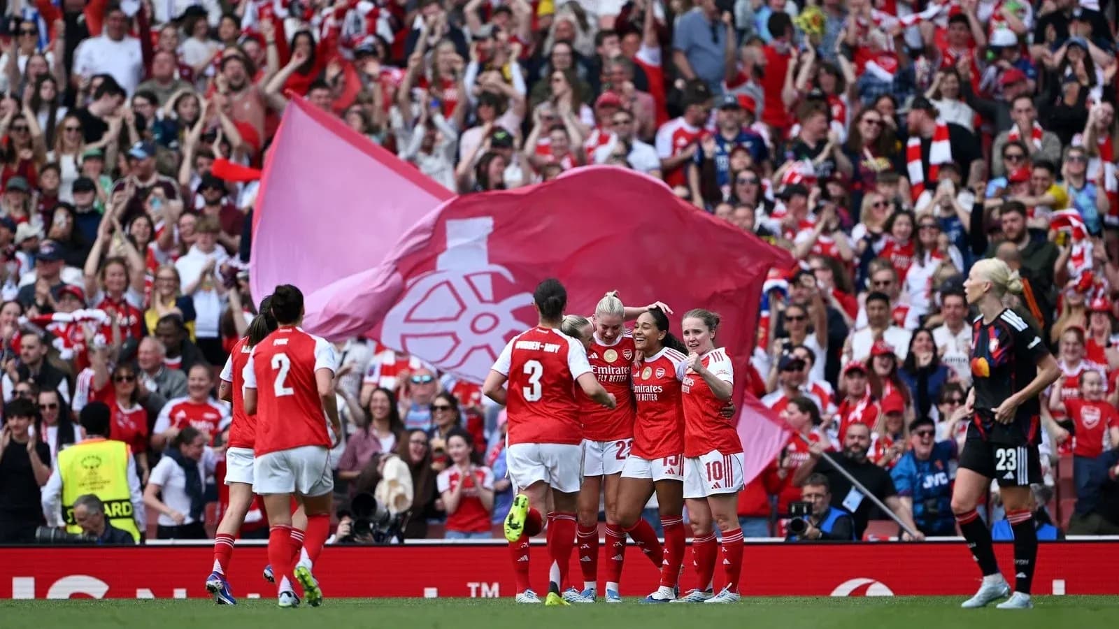 Arsenal women celebrating a goal with fans cheering