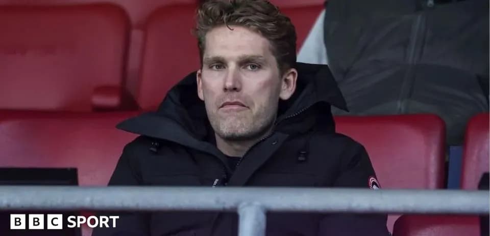 Man sitting in stadium seat wearing a jacket
