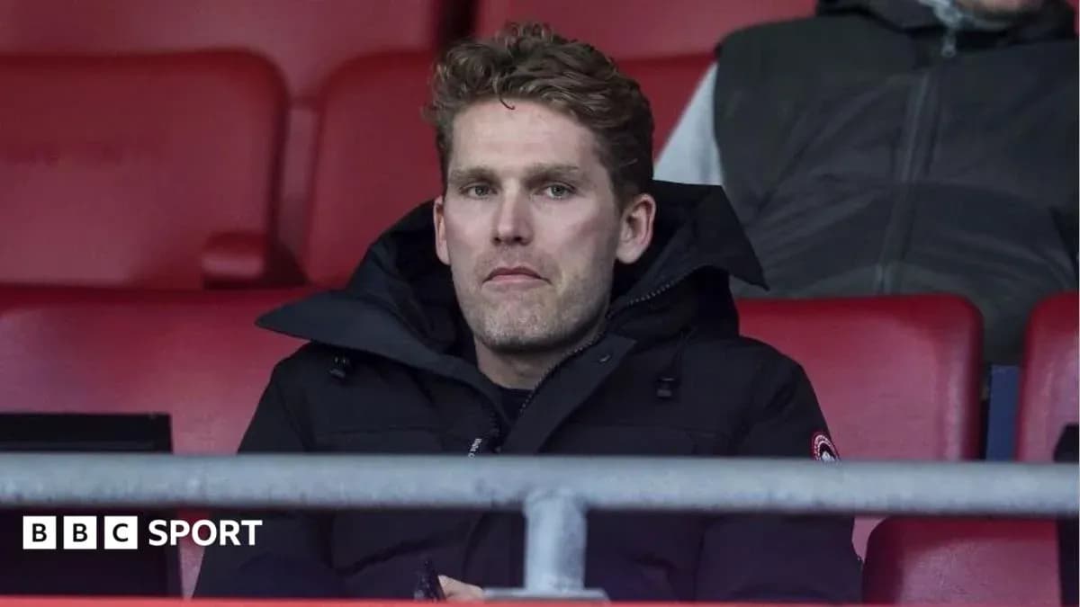 Man sitting in stadium seat wearing a jacket