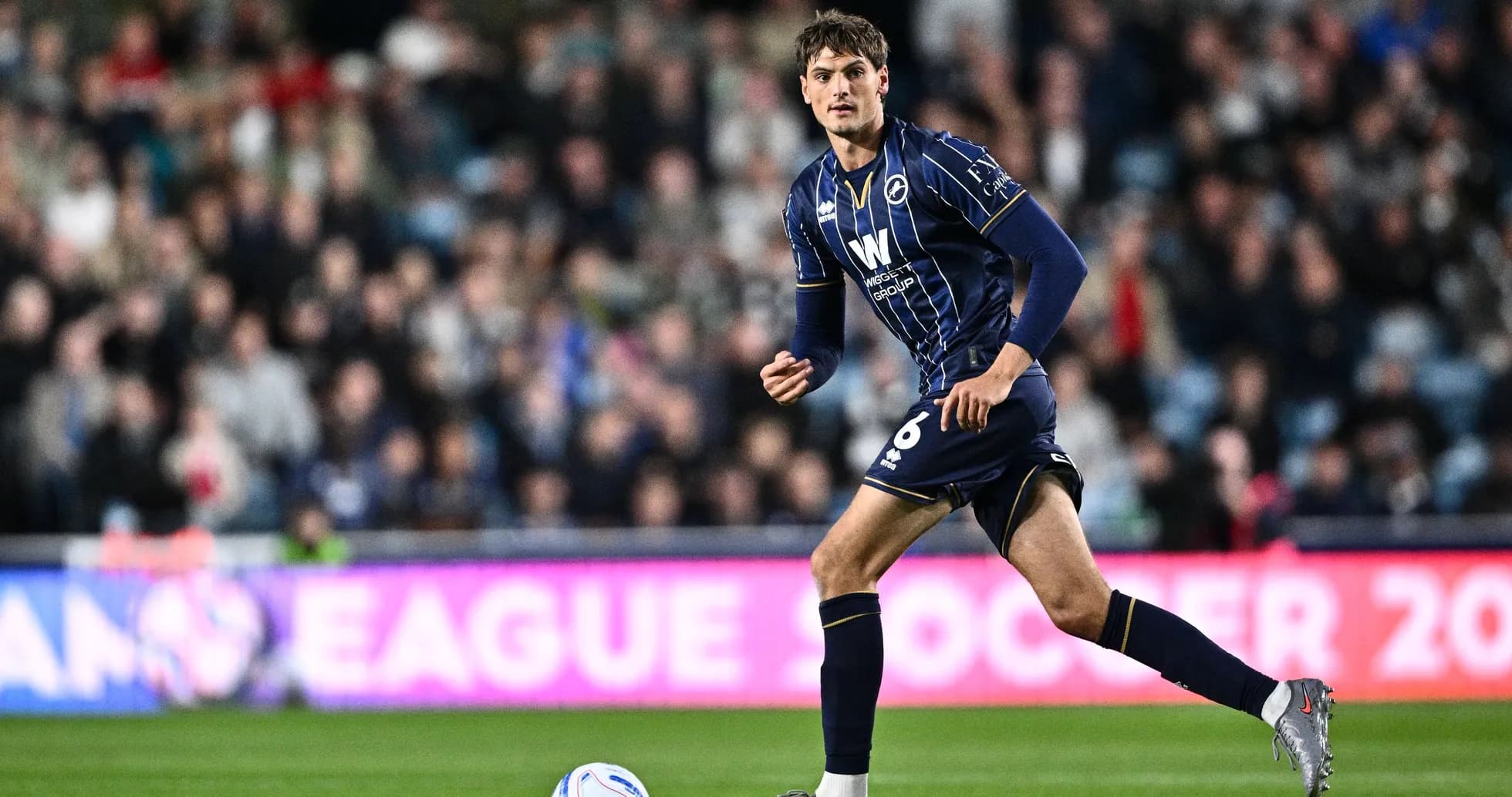 Player in blue kit running on the pitch