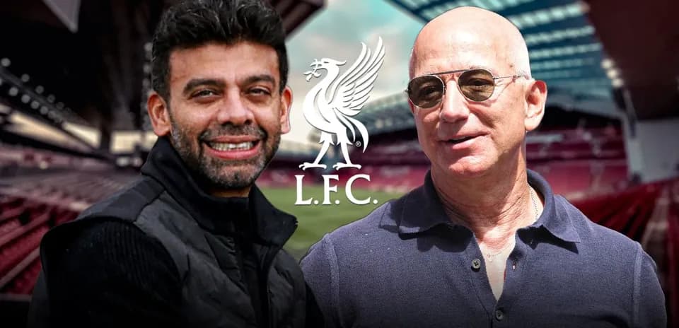 Two men posing in front of Anfield stadium