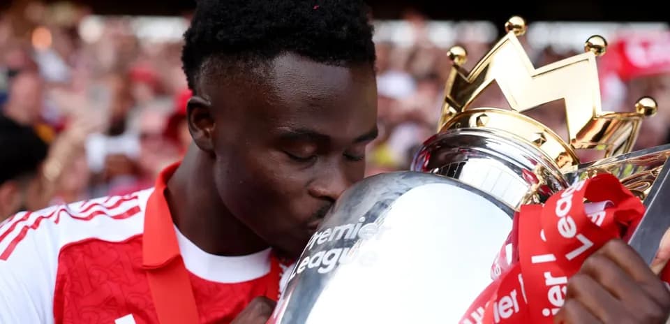 Player kissing the Premier League trophy during celebration