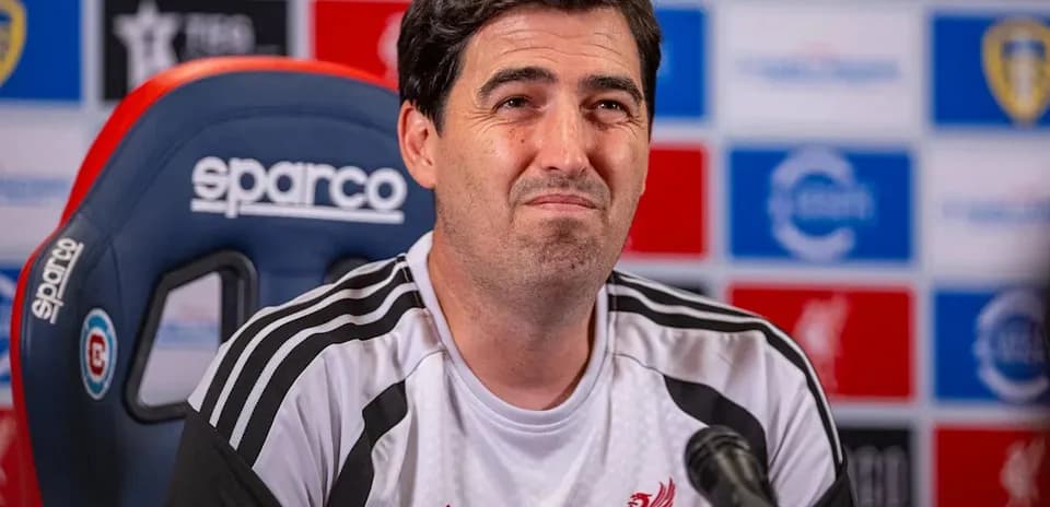 Manager at press conference with Liverpool FC branding
