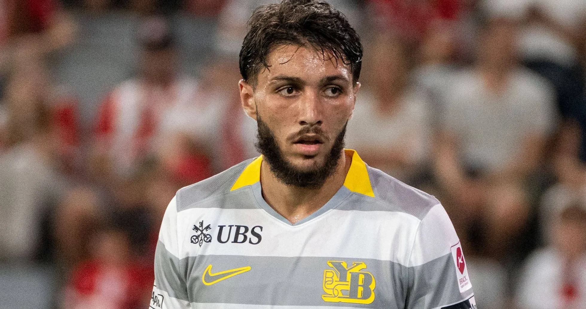 Player wearing gray and yellow jersey during match