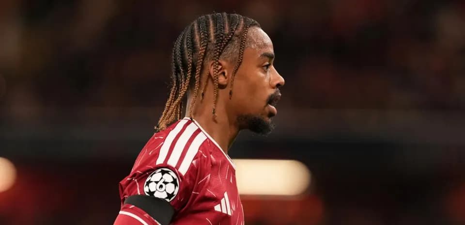 Player in red jersey during match with Champions League badge
