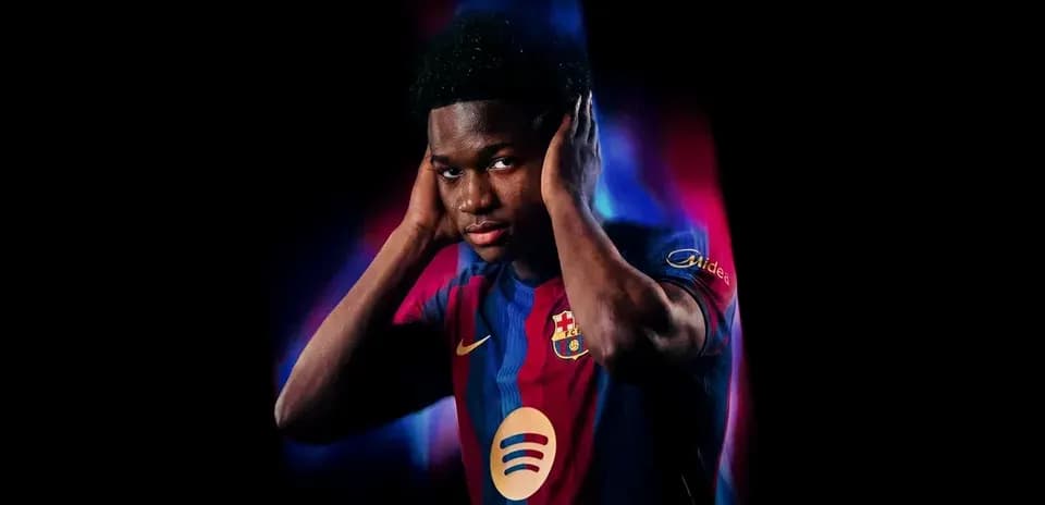 Player posing in FC Barcelona jersey with hands on ears
