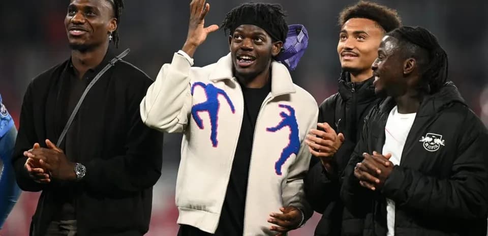 Four players celebrating together at a stadium