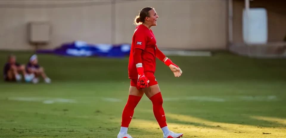 Goalkeeper in red uniform celebrating on the field