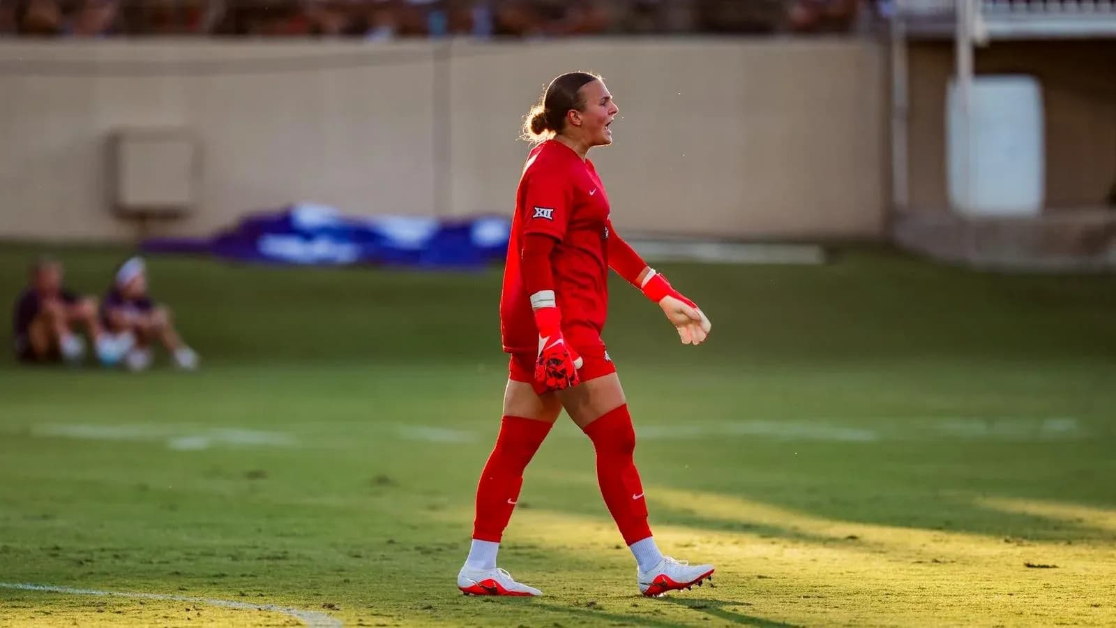 Goalkeeper in red uniform celebrating on the field