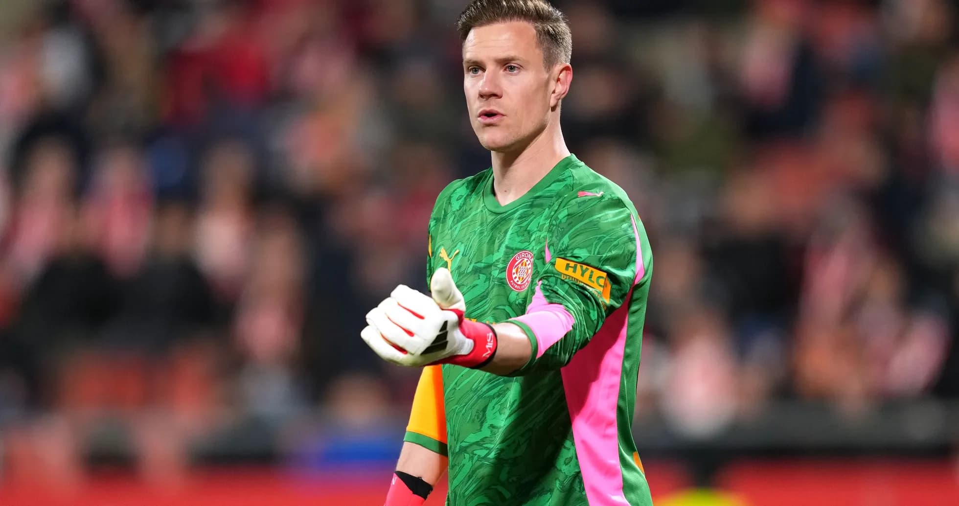 Goalkeeper in green kit gesturing during match