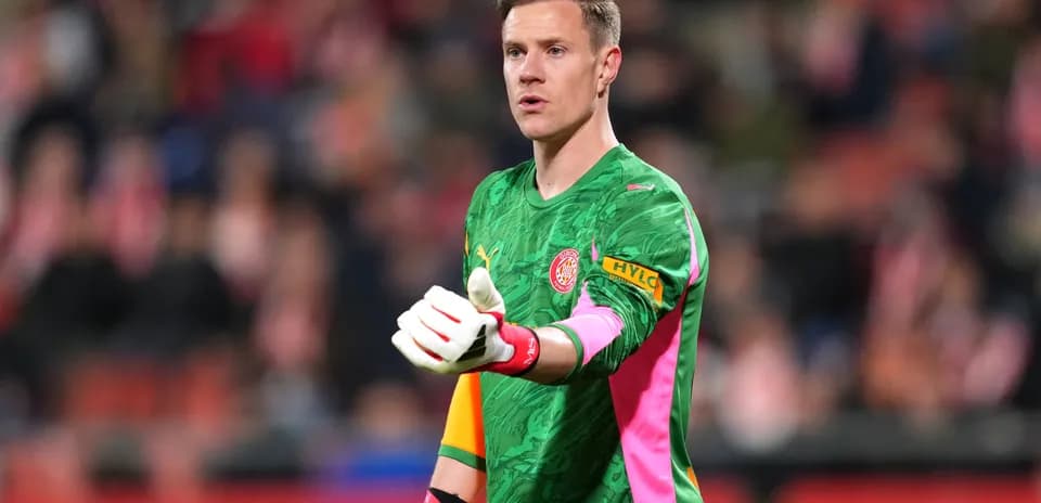 Goalkeeper in green kit gesturing during match
