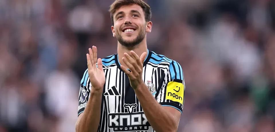 Player applauding fans wearing Newcastle United jersey