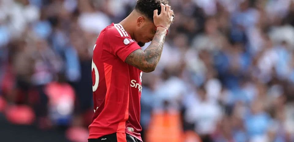 Player in red jersey looking down on the pitch