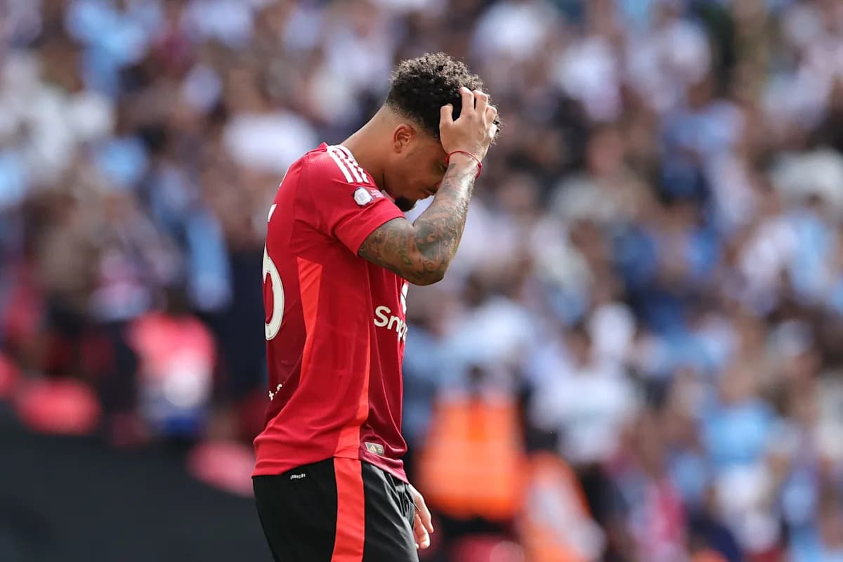 Player in red jersey looking down on the pitch
