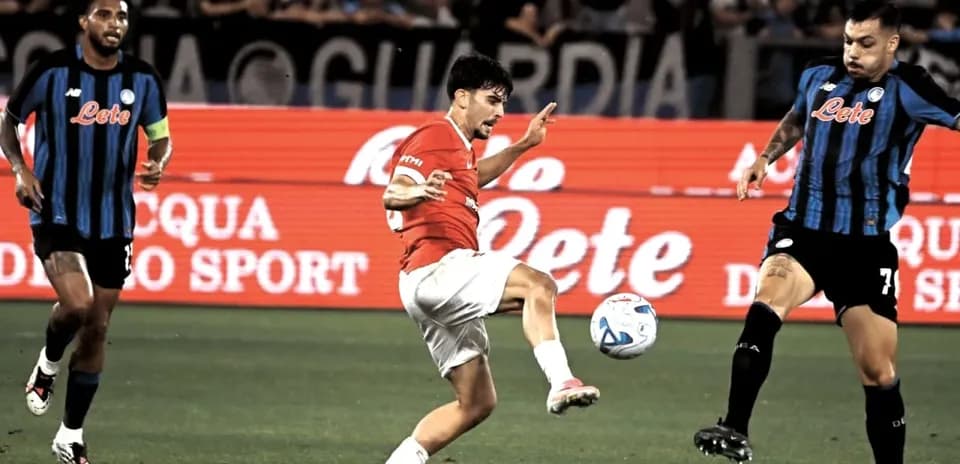 Player kicking ball during match with opponents nearby