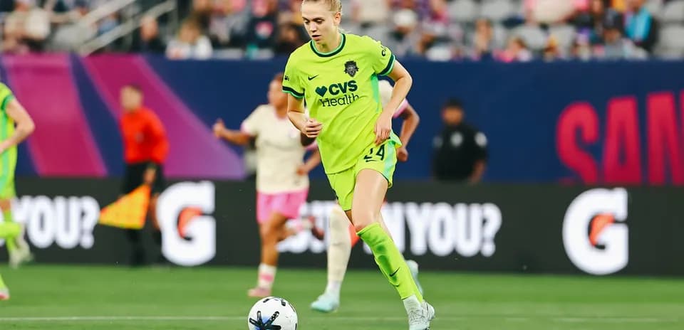 Player in green kit dribbling the ball