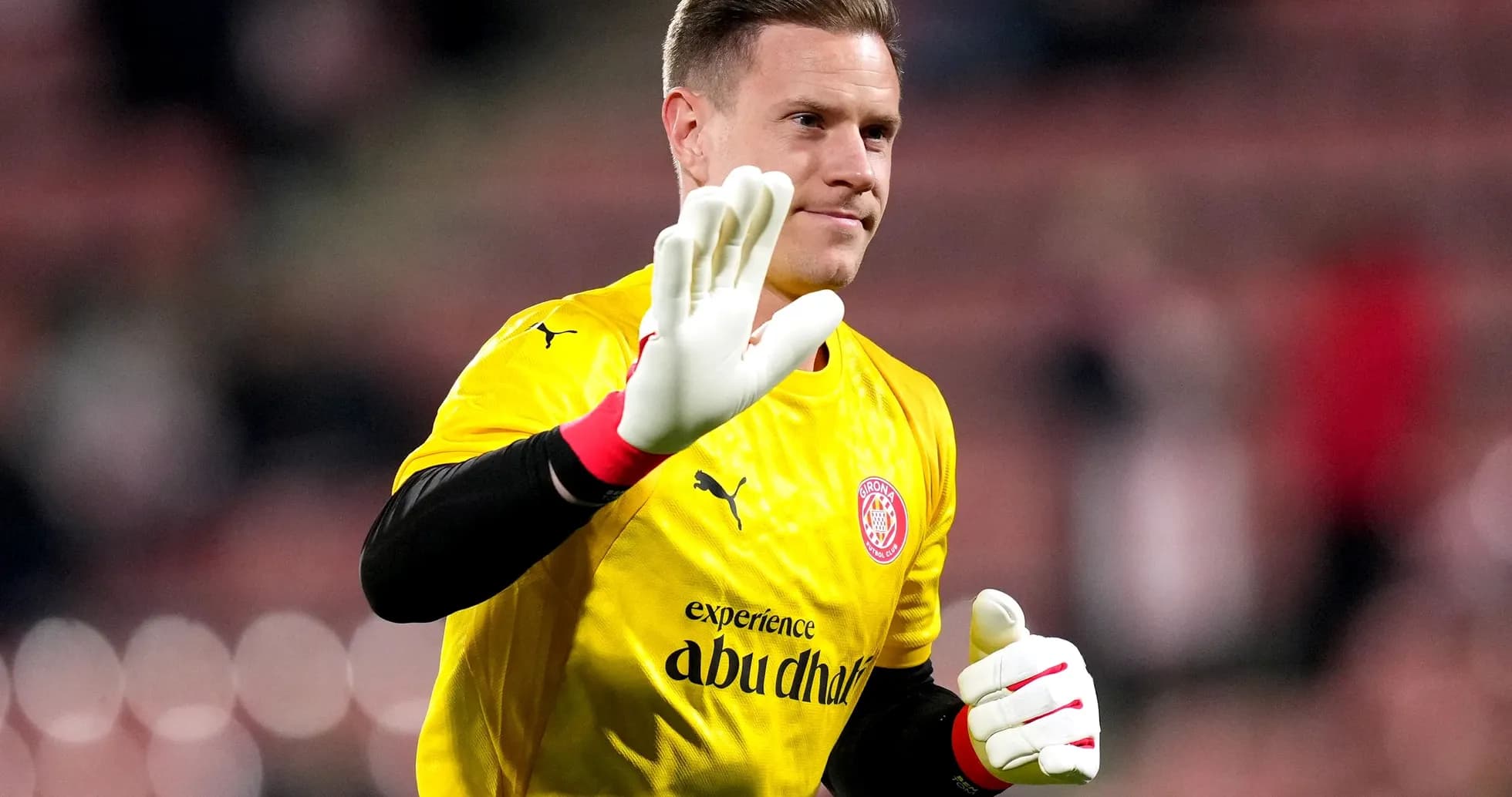 Goalkeeper waving while wearing yellow kit
